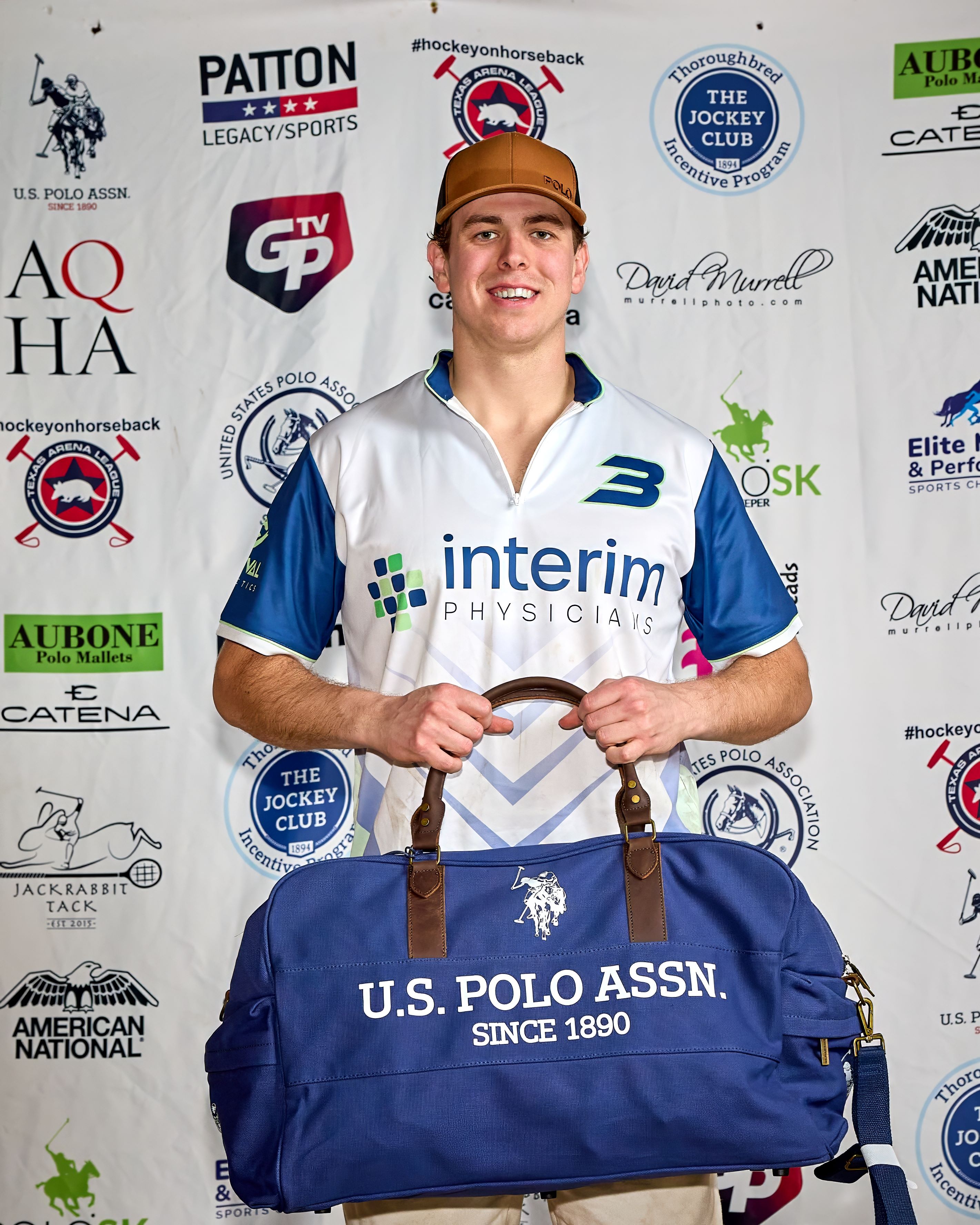 A very happy arena polo player holds his U.S. Polo Assn gear bag for an award photo