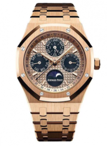 A rose gold watch with 4 tiny dark circles within the dial that say the month, day of the week, day of the month, and the last one says Audemars Piguet