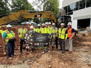 Construction workers pose with a Construction Safety Week 2024 poster