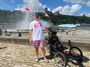 Aaron Novinger riding a bicycle through Pittsburgh, PA on his way to Washington, DC., raising awareness and funds for Ponzi scheme victims during the Pedaling For Ponzis Charity Bike Ride.