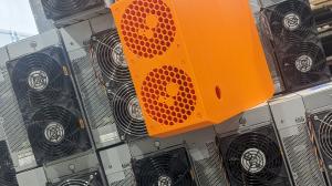The Antminer Slim Edition stands out with its innovative design and dual-purpose functionality, nestled atop a pile of Antminer S19 units, symbolizing the future of efficient and home-friendly Bitcoin mining