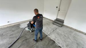 man grinding garage floor prior to polyurea coating installation