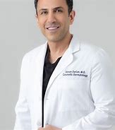 "Dr. Simon Ourian, renowned cosmetic expert at Epione Beverly Hills, wearing a white lab coat and smiling confidently."