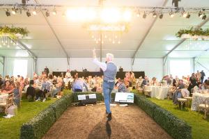 Auctioneer John Curley and guests under the tent at Sonoma County Wine Auction