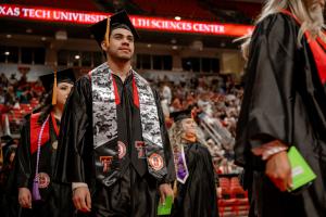A TTUHSC student wears the camo pattern stole recognizing his military service along with his graduation cap and gown