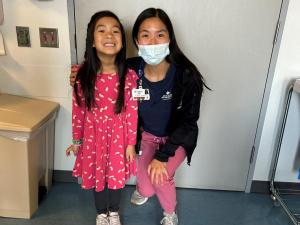 a young girl and her doctor pose for a photo