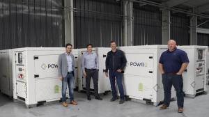 POWR2 and GeniWatt teams in front of POWRBANK battery energy storage systems