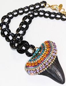 Necklace made of a shark tooth covered in colorful lines of crystals