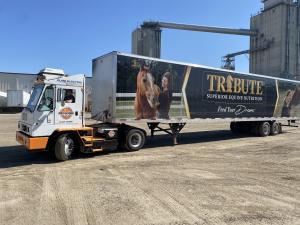 Orange EV truck with Tribute® Equine Nutrition trailer