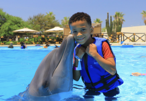 Miracles for Kids Angel Flight, Kharter, enjoying time in the water swimming with dolphins