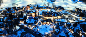 Nighttime view of a ski resort, with slopes covered in snow and buildings lit up, offering a cozy and inviting atmosphere.