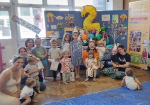 A picture of Emma and the children and some of the parents from her family craft party. Some of the children are wearing the hats the made at the party.