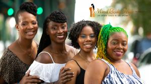 Four smiling African American women of different ages and skin shades, each sporting unique natural hair styles. The business logo and trademark slogan 'an urban oasis in the Bronx' are displayed at the top right