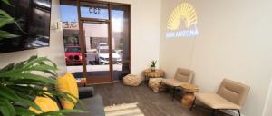 A cozy waiting area with modern seating and the SEEK Arizona logo illuminated on the wall.