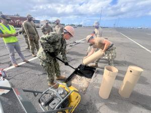 Warfighters using HOTPOD to patch hole with asphalt