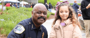 An image of a police officer and a young girl, both smiling.