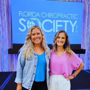 Jill Cherry, Cherry Picked Web Co, in blue and Jenna Quentin, Adjust Your Media in pink in front of the Florida Chiropractic Society logo at their 2024 conference