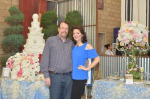 Susan and James Irvine at 2018 standing in front of the replica of their wedding cake and guest table exhibit at the 2018 Orange County Fair in Costa Mesa, California