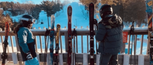 Two young skiers standing side by side, ready to hit the slopes.