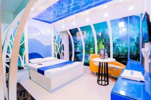 The Mega Suite at Hotel Dreamworld with blue and white decor, a large bed, ambient lighting, and a futuristic wall design.