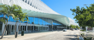 The modern exterior of the Miami Beach Convention Center is shown on a sunny day.