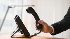 Homem segurando telefone em suas mãos em um escritório comercial
