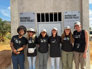 Students in front of a Mapinduzi water project plaque