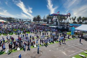 Overview of the Throw Down Cornhole Festival at Ventura County Fairgrounds with main stage, cornhole boards and scores of players