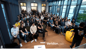 A large group of participants attentively listens to a presentation at the Hacking Big Numbers Hackathon in Bucharest. The event, organized by Veridion, focuses on AI and business data challenges, bringing together data scientists, machine learning expert