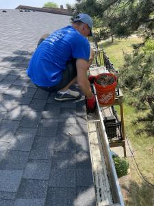 man on the roof cleaning gutter