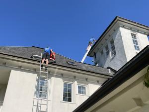 cleaning gutters using tall ladder