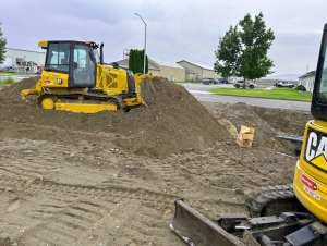 A professional team from Elevate Excavation and Development grading a construction site using advanced equipment to ensure a stable and level foundation.