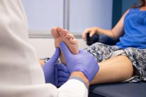 The hands of a doctor are wrapping a foot with a bandage, providing high quality wound care.