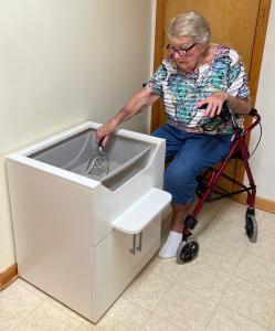 Elderly lady can safely and easily clean LoftyLoo™ Raised Litter Box in her wheelchair