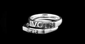 two silver rings, one with the word "brat" and one with the word "vote" in raised lettering