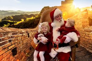 Santa Claus with participants "on the Great Wall of China" for this example of a green screen photo booth for Christmas around the world