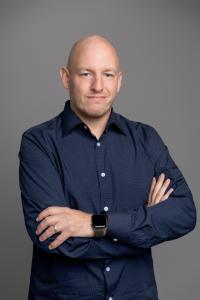 A headshot of Chris Carter, Vice President of NISCL-CSCL, wearing a dark blue shirt.