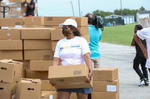 Volunteer loads food boxes into the vehicle.