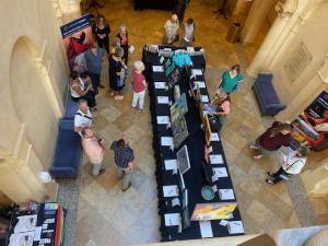 Overhead shot of attendees viewing art at the Expressions Exhibition, featuring works by local LGBTQ+ youth and professional artists.