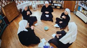 five sisters on the floor of a yurt engaged in prayer