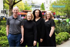 4 people dressed in black standing in front of a red trolley resound training logo