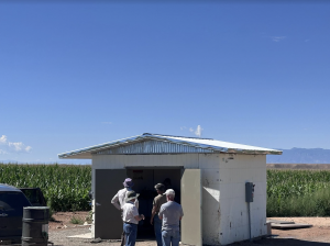 small blockhouse structure with blue sky and mountains in the background