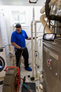 J. Blanton Plumbing technician performing a camera sewer inspection, highlighting the No Drip Club's VIP Priority Scheduling and comprehensive plumbing maintenance services.