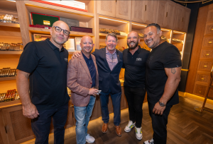 Group photo at the NFL kickoff Cigars and Conversation event hosted at Eight Cigar Lounge featuring John Pettei, Levi Rogers, Mark O'Neil, Scott Diel, and Rich Robledo. The event combines professional networking with a premium cigar experience