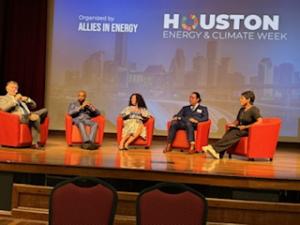 Four panelists and moderator on stage discussing the pragmatic realities of a lower carbon future