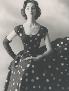 Black and white photo of caucasian woman in a polka dot Balenciaga dress and gloves