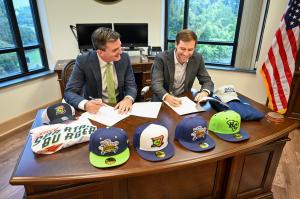 two people signing a document