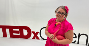 Katie Hornor, TEDx Speaker holding flamingo on stage