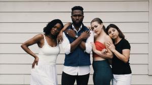 Mr. FoW stands in the middle with arms crossed while two women stand closely by his side in a united pose.