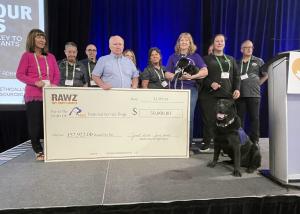 RAWZ Natural Pet Food owners, Janet and Jim Scott, present a $50,000 check to Danielle Forbes and Lynne Davidson from National Service Dogs, along with John Ayers from Freedom Pet Supplies and other Freedom team members at the Pets Canada Industry Show in Toronto.